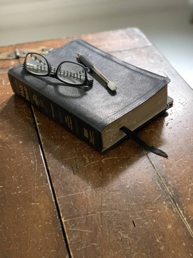 a-black-leather-bible-sits-atop-an-old-weathered-w-2022-10-19-05-05-51-utc